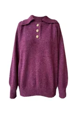 Sweater burdeo de punto con cuello polo, manga raglán, calce relajado y pretina ancha. Tiene tres botones dorados en forma de hoja.