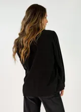 Camisa de pana color chocolate, con cuello alto tipo mao con volados, cierre frontal de botones y mangas largas con puños abotonados.