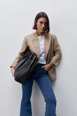 Jean flare de tiro alto, color azul, con calce ajustado en cadera y muslos, y ruedo desflecado.