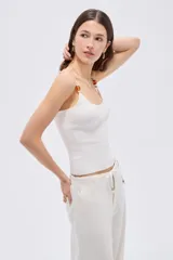 Musculosa de viscosa al cuerpo con cuello redondo y breteles finos decorados con cuentas.