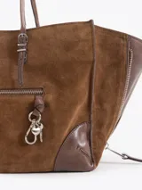 Cartera tote de cuero vacuno color blanco, de diseño estructurado con fuelles laterales expandibles mediante cierres y bolsillos externos con cierre y tiradores metálicos personalizados.
