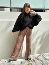 Sweater negro tejido con cuello alto y mangas murciélago.