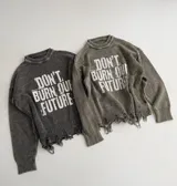 Sweater de punto color gris con efecto desgastado, cuello redondo, mangas largas y detalle de ruedo desflecado. Presenta una estampa frontal con la frase 'Don't burn our future' en color blanco.