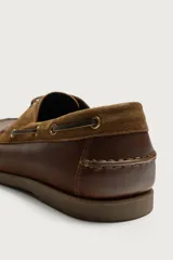 Mocasín náutico de cuero marrón, con cordones de cuero, ojales metálicos y detalles en gamuza a tono.