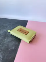 Billetera pequeña de cuero color verde lima, con cierre metálico y monedero interno.