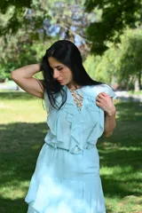 Vestido largo color beige con volados en el escote y falda escalonada.