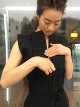 Mono largo de lino color beige, con detalle plisado en el frente, escote en V, sin mangas, lazo en la cintura, cierre invisible delantero y bolsillos laterales.