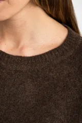 Sweater de tejido de punto color bordó, con cuello redondo, mangas largas y puños acanalados. Presenta un diseño de corte recto y textura suave.