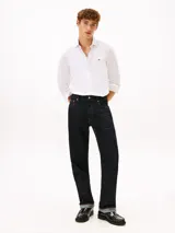 Camisa de vestir Tommy Hilfiger de color blanco, corte slim y manga larga. Presenta cuello camisero, cierre frontal con botones, puños abotonados con vuelta estampada en el interior y el logo de la marca bordado en el pecho.