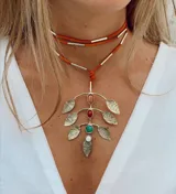 Gargantilla corta con doble tira de cuero naranja y detalles de metal plateado. Dije colgante con forma de rama con hojas de alpaca y piedras naturales de color naranja, rojo, turquesa y blanco.