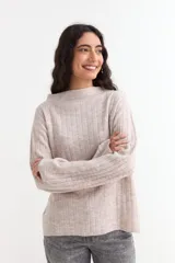 Sweater de punto acanalado en color beige, con cuello bote y mangas largas tipo oxford. Presenta un diseño holgado y textura suave.