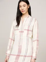 Vestido midi de corte amplio con estampado de cuadros, cuello mao, media cartera con botones ocultos, dos bolsillos de parche en el pecho y mangas largas. Incluye cinturón para ajustar la silueta.