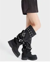 Botas negras de caña alta con hebillas y taco bajo.