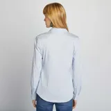 Camisa de corte ajustado en color azul claro, con cuello italiano, cierre frontal de botones y mangas largas con puños abotonados.