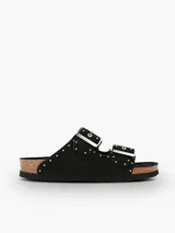 Sandalia plana Genuins modelo Honolulu, de color negro con tachas metálicas decorativas. Cuenta con dos tiras ajustables con hebillas plateadas, plantilla anatómica de corcho natural y suela de EVA.