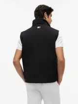 Chaleco negro con cuello chimenea, cierre de cremallera oculto con botones a presión y dos bolsillos laterales ribeteados. Presenta logos bordados en el pecho de Tommy Hilfiger y Cadillac Formula 1 Team.