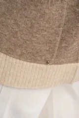 Cardigan abierto de punto con diseño de bloques de color en tonos beige, marrón y bordó. Presenta mangas largas, corte recto y bolsillos frontales aplicados.