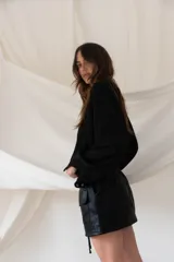 Minifalda color beige con cintura elástica, cierre frontal con cremallera y cordón ajustable, y bolsillos tipo cargo con solapa.