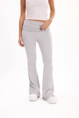 Pantalón calza gris melange de corte flare, tiro alto con cintura rebatible ancha y ajuste entallado en las piernas que se ensancha hacia los tobillos.