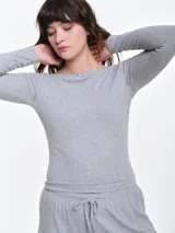 Remera de manga larga entallada en tejido pointelle, con escote bote y detalle de pequeño lazo central. Presenta un acabado con borde picot en el escote.