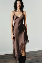 Vestido midi marrón satinado con escote en V, tirantes finos regulables, espalda descubierta con lazo y bajo asimétrico con encaje a tono.