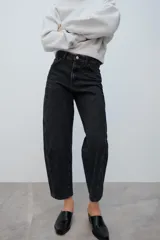 Jeans de tiro medio con diseño de volumen crop y perneras curvas. Presenta cinco bolsillos, cierre frontal con cremallera y botón metálico.