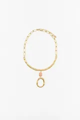 Collar dorado con cadena de eslabones y dije colgante con forma orgánica y piedra rosada.