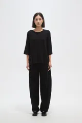 Remera de viscosa en color verde oliva, con cuello redondo y mangas 3/4. Presenta un diseño de tejido acanalado y corte holgado.