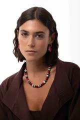 Collar corto compuesto por cuentas de amazonita, ágata tibetana y acrílico en tonos rojos, negros, blancos y celestes. Cuenta con cadena de acero quirúrgico para ajuste de largo.