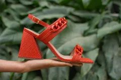 Sandalias de cuero celeste con puntera cuadrada, tira delantera con detalle de cadena y pulsera al tobillo con hebilla metálica. Tacón geométrico con detalle dorado.