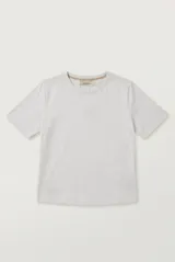 Remera de manga corta y cuello redondo color crudo, corte clásico y holgado.