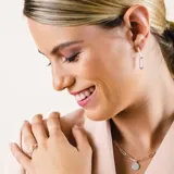 Conjunto de joyas en plata 925 que incluye collar, anillo y aros. El collar es de cadena de eslabones con dije de medalla circular. Los aros son colgantes con forma de eslabón. El anillo es de eslabones.