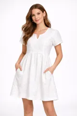 Vestido corto negro de broderie, con mangas cortas abullonadas y escote en V. Presenta un corte imperio con frunce en la cintura y falda acampanada.