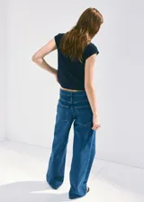 Jeans de tiro medio con diseño de pernera recta, estilo clásico de cinco bolsillos, presillas para cinturón y cierre frontal con botón y cremallera.