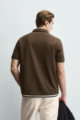 Polo de corte regular fit en tejido de algodón con estructura vertical color beige. Presenta cuello solapa, cierre frontal de botonadura y manga corta con rib.