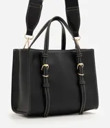 Cartera satchel mediana de color marrón, confeccionada en poliuretano con diseño estructurado, costuras en contraste y herrajes metálicos dorados. Cuenta con doble asa de mano, correas decorativas verticales con hebillas en la parte frontal y una correa larga ajustable y desmontable para llevar al hombro o cruzada.