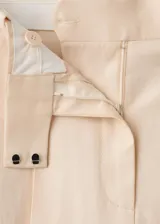 Pantalón wide leg de tiro bajo color beige, con trabillas y dos bolsillos laterales.