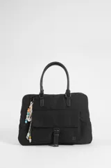 Briefcase negro de nylon con tres compartimentos, dos con cierre, bolsillo delantero con solapa y cierre de broche a presión. Cuenta con doble asa de mano, correa regulable y un llavero decorativo con cuentas coloridas colgando de uno de los herrajes.