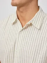 Camisa de manga corta con diseño a rayas verticales finas, cuello clásico y cierre frontal con botones.