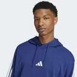 Canguro Adidas de felpa francesa color azul, con capucha y cordón ajustable, bolsillo canguro frontal y hombros caídos. Cuenta con las icónicas tres tiras blancas en las mangas y el logo de la marca bordado en el pecho.