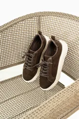Zapatillas urbanas de cuero, color marrón oscuro, con paneles de gamuza y cuero liso, cordones al tono y suela de plataforma blanca.