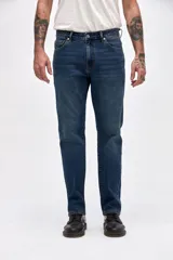 Jean de corte recto clásico con cadera levemente holgada, en tono azul medio con efecto de lavado sutil.