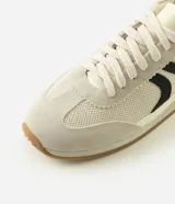 Championes estilo runner de diseño vintage, confeccionados en una combinación de tejido de malla respirable, recortes de gamuza y detalles en material sintético. Presentan cierre con cordones, detalle lateral aplicado en contraste y suela de goma plana con base color caramelo.