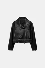 Chaqueta tipo biker de piel negra con solapas, cierre frontal asimétrico con cremallera, bolsillos con cierre y cinturón ajustable con hebilla metálica en la cintura.