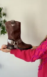 Bota de cuero marrón con estribo desmontable plateado.