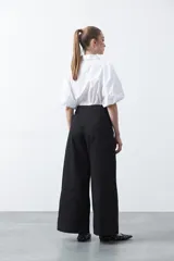 Pantalón wide leg de corte sastrero, color negro, con cintura de tiro medio y diseño de pernera amplia y relajada.