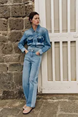 Cazadora corta de denim con cuello solapa y manga larga. Presenta un diseño de lavado combinado a contraste, con bolsillos de plastrón con solapa en el pecho y cierre frontal con botones metálicos.