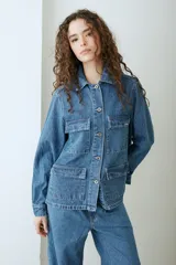 Campera de denim azul con múltiples bolsillos frontales con solapa, cierre frontal de botones metálicos y cuello camisero.
