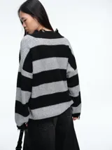 Sweater de tejido de punto con diseño a rayas horizontales en negro y gris. Presenta cuello en V con terminaciones desflecadas, corte holgado y mangas largas con puños desflecados.