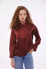 Camisa color verde oliva de satén con cuello clásico, corte holgado y mangas largas con puños abotonados.